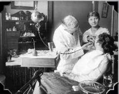 Dr. Sinton working on patient, circa 1915